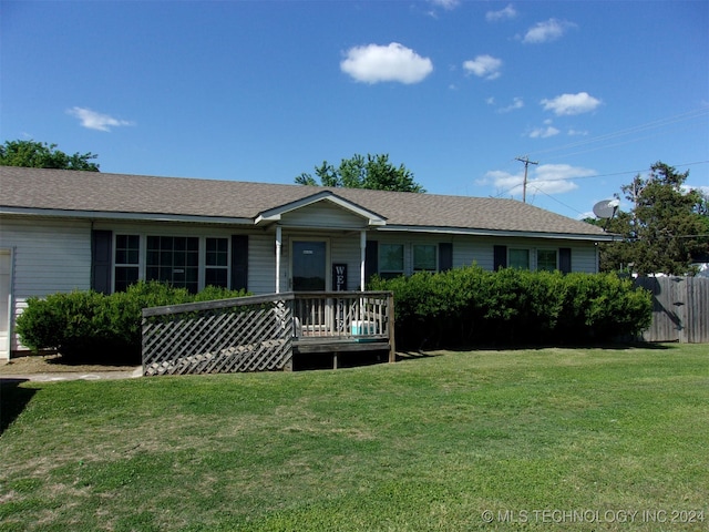 ranch-style house featuring a wooden deck and a front yard