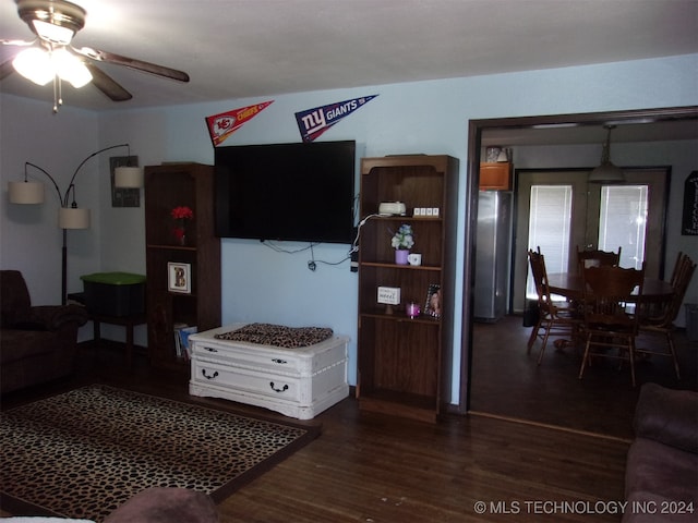 living room featuring ceiling fan and dark hardwood / wood-style flooring