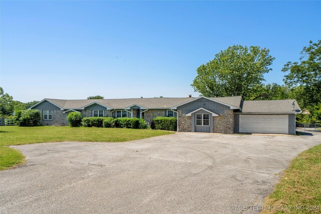 single story home featuring a garage and a front yard