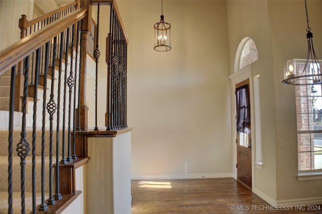 foyer entrance with dark wood-type flooring and a chandelier