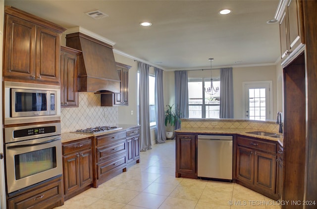 kitchen featuring appliances with stainless steel finishes, premium range hood, ornamental molding, and sink