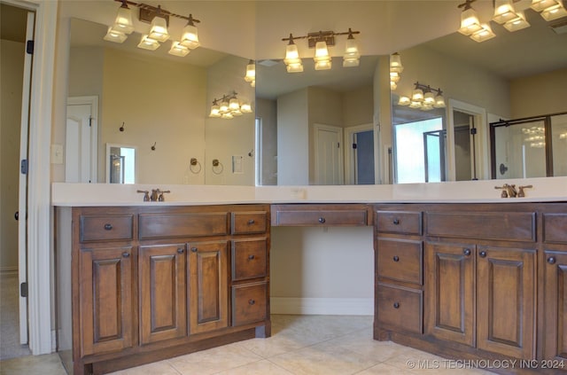 bathroom with tile patterned floors, a shower with door, and vanity