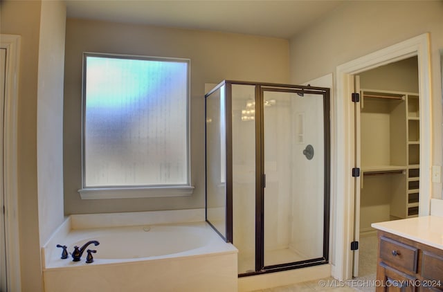 bathroom with vanity and shower with separate bathtub