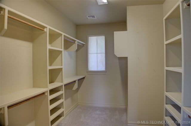 walk in closet featuring light carpet