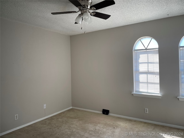 carpeted empty room featuring a textured ceiling and ceiling fan