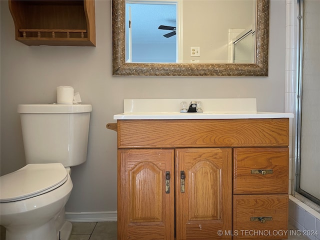 bathroom with tile patterned floors, a shower with shower door, vanity, and toilet