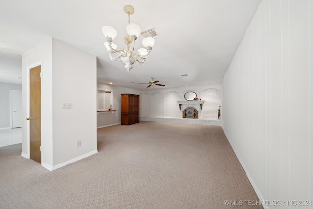 unfurnished living room with carpet flooring, ceiling fan with notable chandelier, and a fireplace