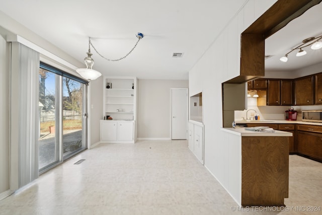 kitchen with dark brown cabinets, hanging light fixtures, and sink