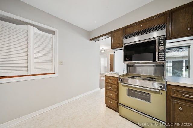 kitchen with dark brown cabinetry and appliances with stainless steel finishes