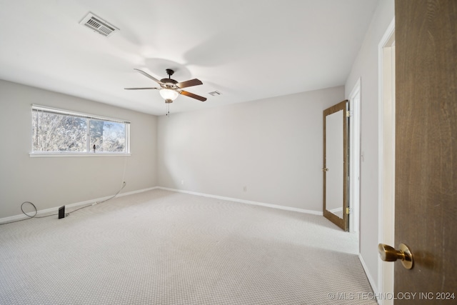 carpeted spare room with ceiling fan