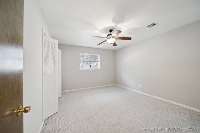 unfurnished room featuring ceiling fan and light carpet