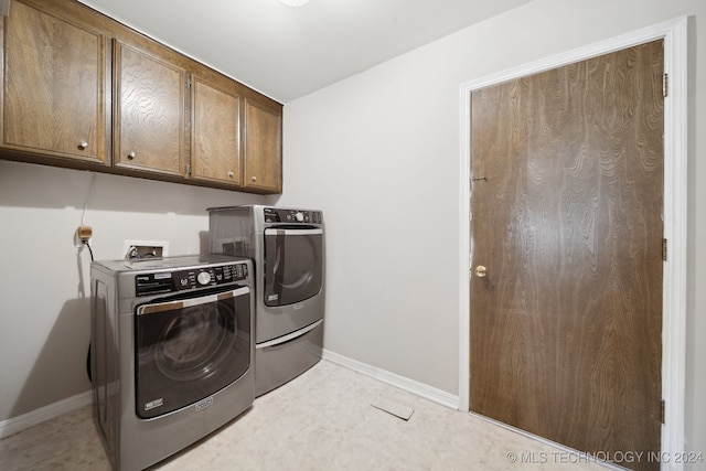 laundry area with washer and clothes dryer and cabinets