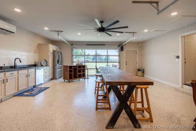 dining area featuring ceiling fan, sink, and a wall mounted air conditioner