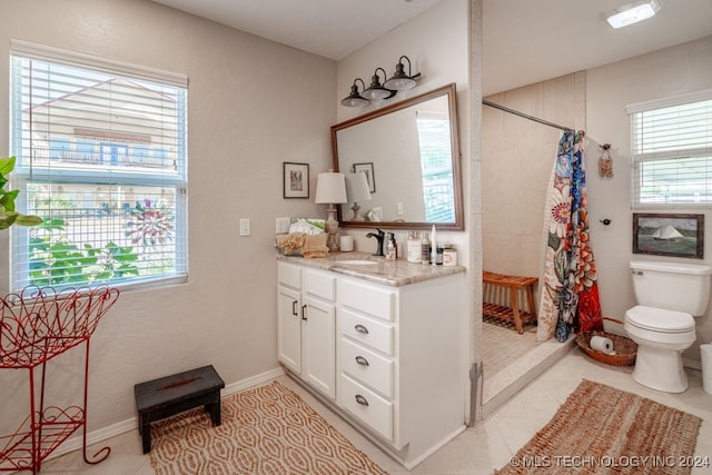 bathroom featuring tile patterned flooring, plenty of natural light, toilet, and vanity