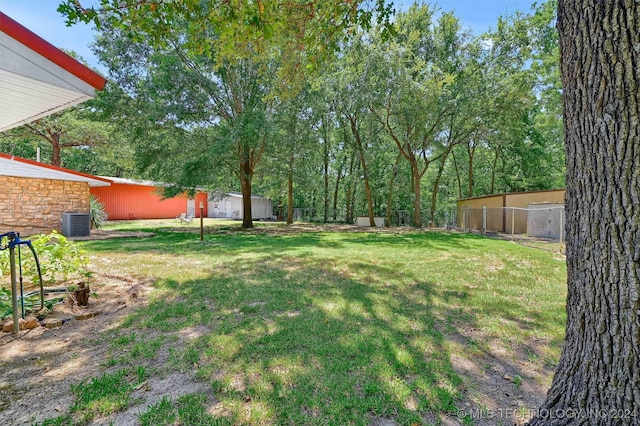 view of yard with central AC and fence