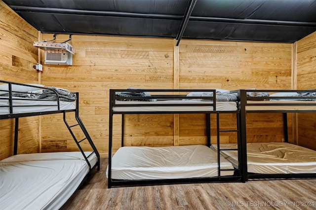 bedroom with wooden walls and wood finished floors