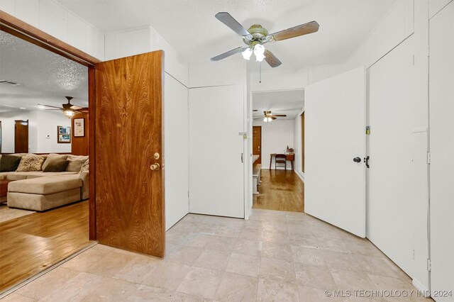 corridor with a textured ceiling and light tile patterned floors