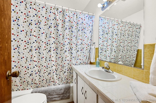 bathroom with toilet, shower / bath combination with curtain, and vanity