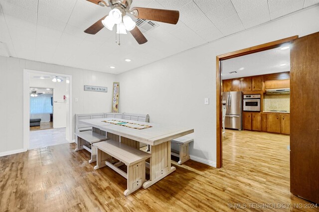 dining space with light hardwood / wood-style flooring and ceiling fan