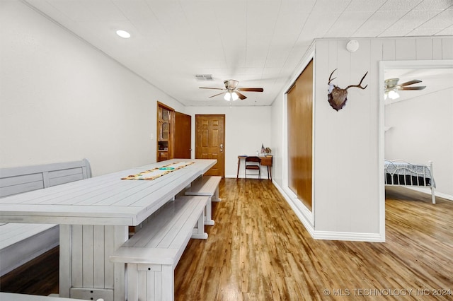 dining space featuring a ceiling fan, wood finished floors, visible vents, and baseboards