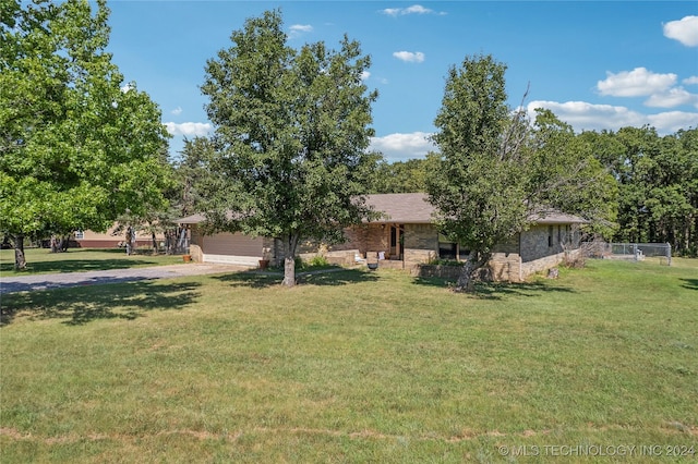 ranch-style home with a garage, a front yard, fence, and driveway