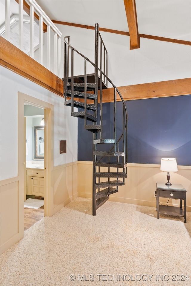 stairs featuring beamed ceiling