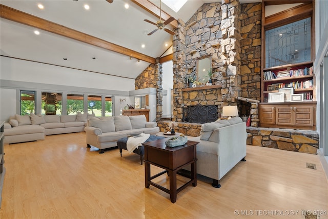 living room with ceiling fan, beam ceiling, light hardwood / wood-style flooring, high vaulted ceiling, and a fireplace