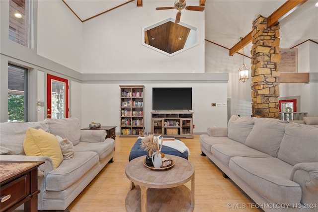 living room with light hardwood / wood-style floors and high vaulted ceiling