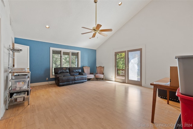 living room with ceiling fan, light wood-type flooring, plenty of natural light, and high vaulted ceiling