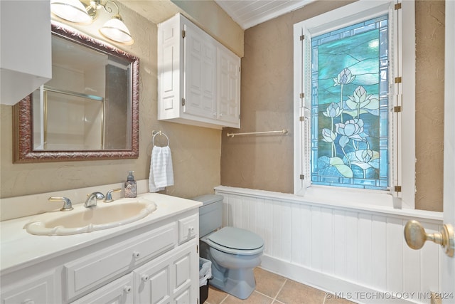 bathroom with vanity, toilet, tile patterned floors, and a shower with shower door