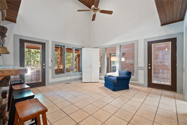 interior space featuring light tile patterned floors, a high ceiling, wood ceiling, and ceiling fan