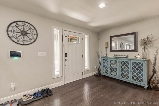 foyer with dark wood-style floors and baseboards