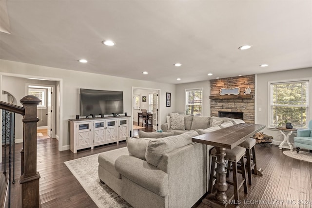 living room featuring dark wood-type flooring, a healthy amount of sunlight, and stairway