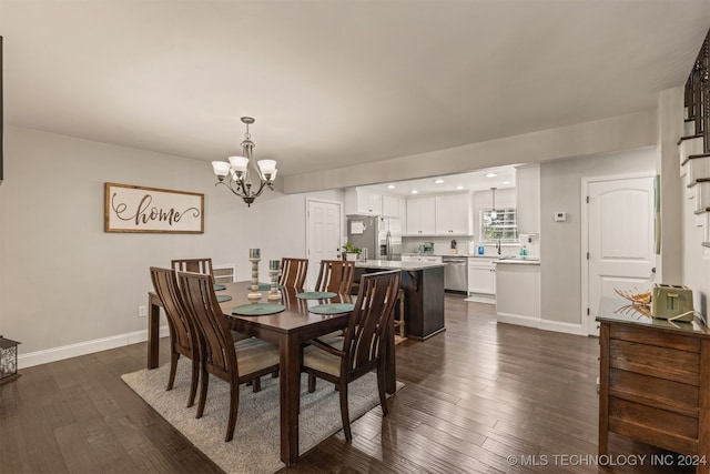 dining space featuring dark hardwood / wood-style flooring, an inviting chandelier, and sink