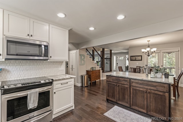 kitchen featuring an inviting chandelier, appliances with stainless steel finishes, light stone counters, decorative backsplash, and dark hardwood / wood-style floors