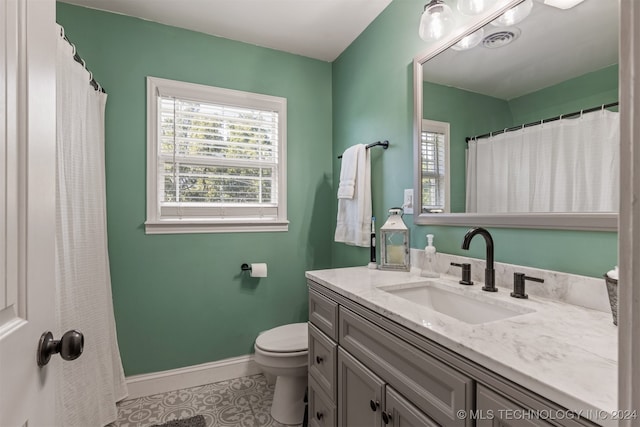 bathroom with tile patterned flooring, vanity, and toilet