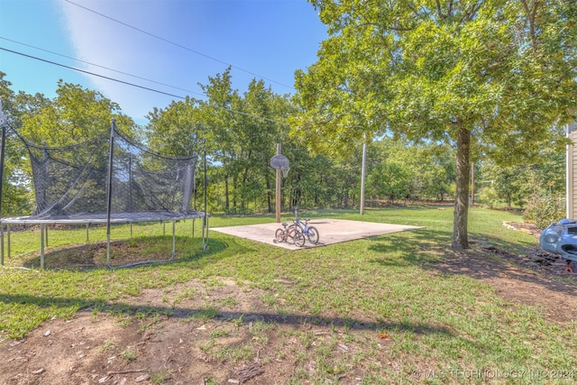 view of yard with a trampoline and a patio area