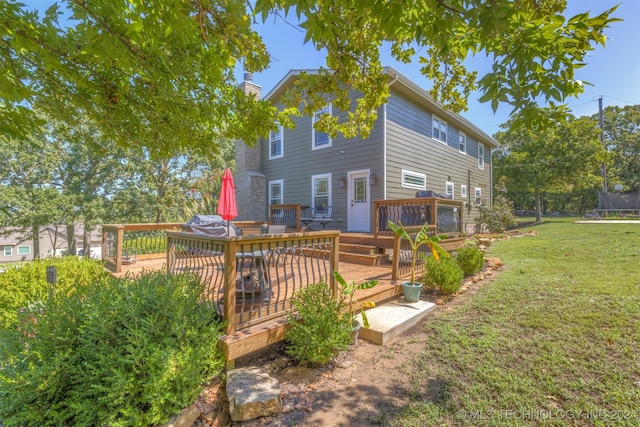 back of property featuring a deck and a yard