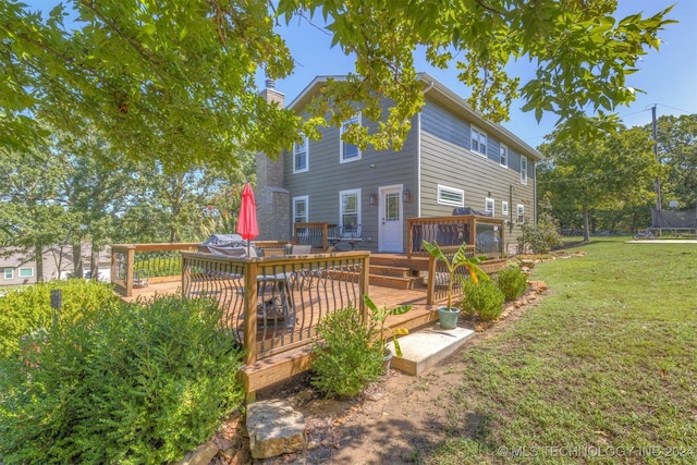 rear view of house featuring a trampoline, a lawn, a chimney, and a wooden deck