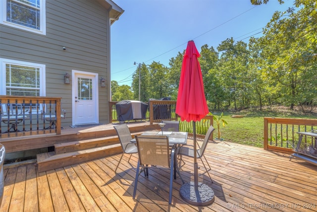 wooden terrace with a yard and a grill