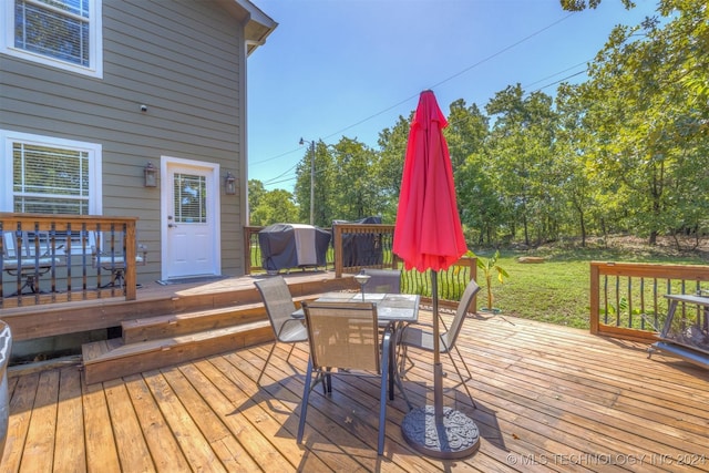 wooden terrace with outdoor dining area and area for grilling