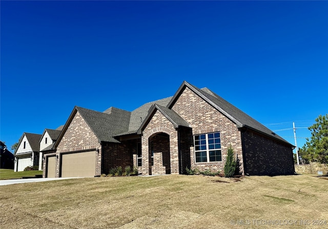 view of front of property featuring a garage and a front lawn