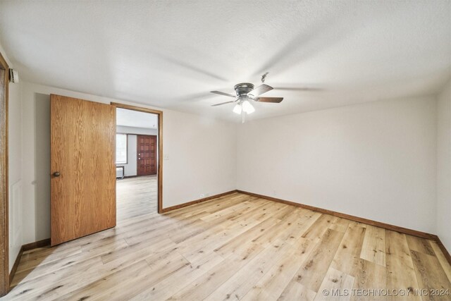 spare room with ceiling fan, a textured ceiling, and light hardwood / wood-style floors