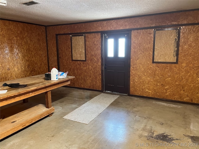 foyer with a textured ceiling and concrete floors