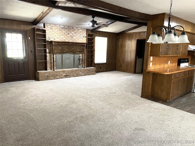 2912 Michelle, Durant, OK 74701 - unfurnished living room featuring wooden walls, beamed ceiling, carpet flooring, and a textured ceiling