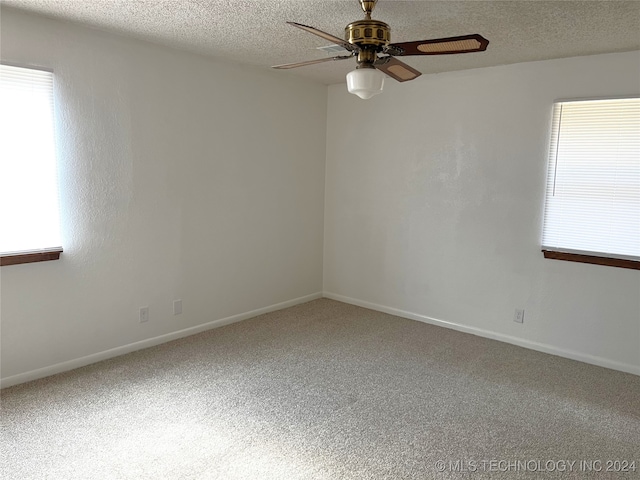 carpeted empty room featuring ceiling fan and a textured ceiling