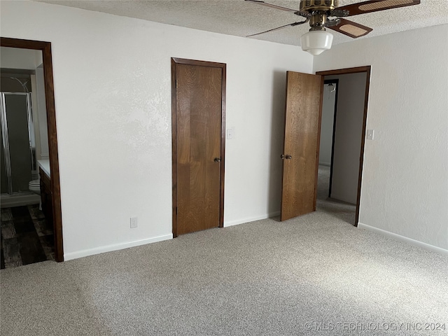 unfurnished bedroom with ceiling fan, carpet flooring, connected bathroom, and a textured ceiling