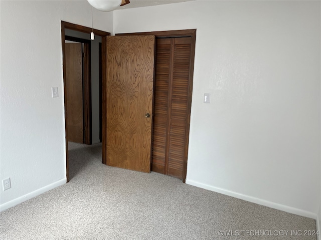 unfurnished bedroom with a closet and carpet floors