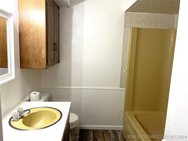 bathroom with toilet, vanity, and wood-type flooring