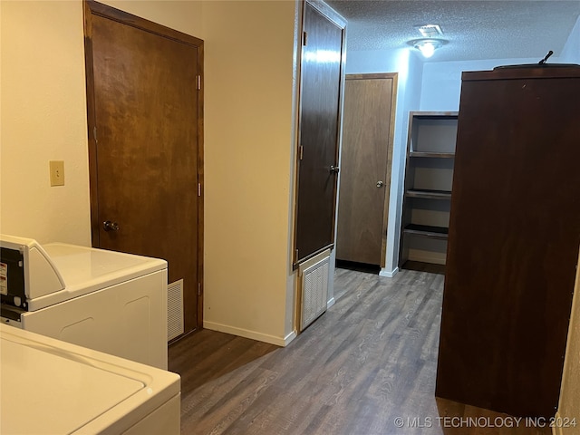 laundry area with a textured ceiling, washer / dryer, and dark hardwood / wood-style floors